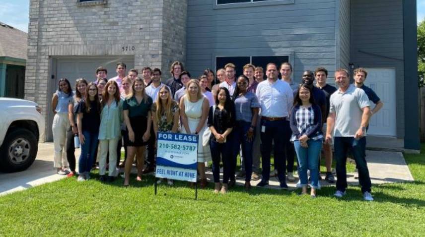 Interns standing in front of a house