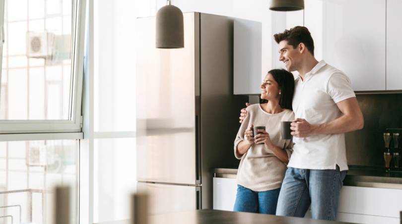 A happy young couple standing in new home